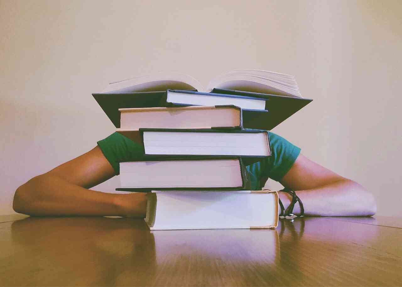 Студент завален книжками во время учебы